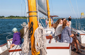 Guests on the deck of a schooner enjoying a sail in Newport RI