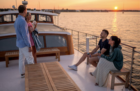 Guests on the bow of yacht full moon at sunset in Newport RI