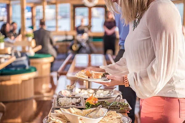 Newport_Private-Boat-Charters_Catering-Options a close up of a woman grabbing food off of a table