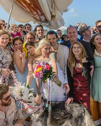 a large wedding party celebrating a very special day aboard a sailboat