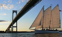 Newport_Private-Boat-Charters_Schooner-Adirondack-II the schooner adirondack II sailing under an overarching bridge