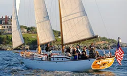 Newport_Private-Boat-Charters_Schooner-Madeleine the schooner madeleine cruising down the river with passengers on board